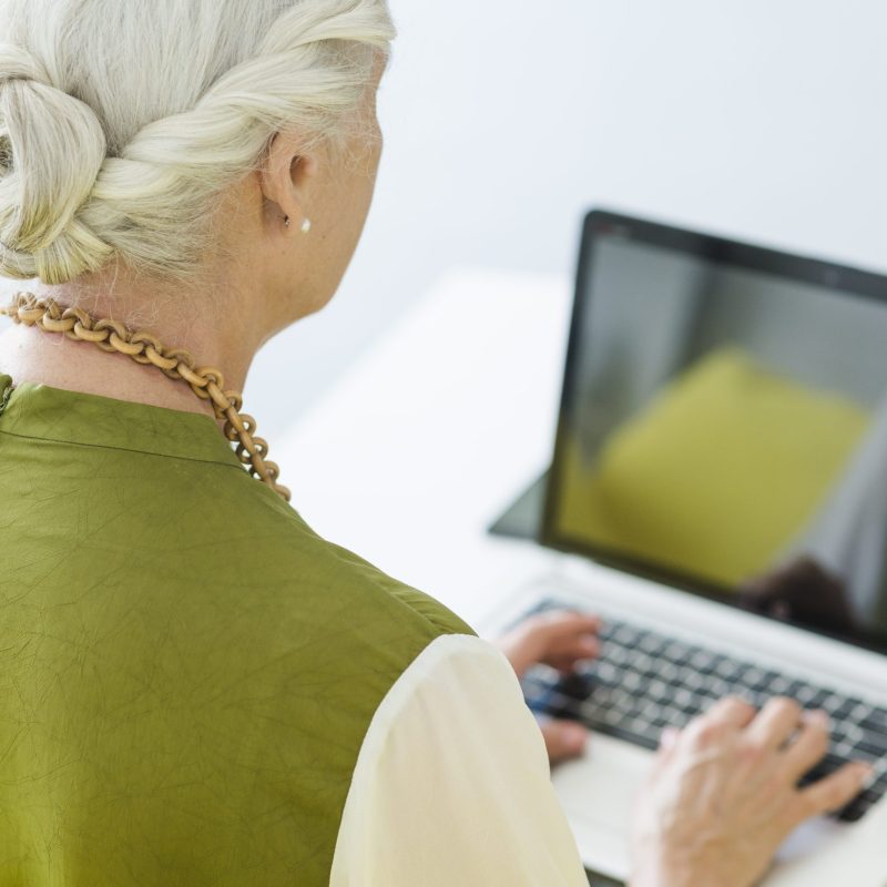 close-up-senior-woman-typing-laptop